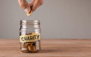 Dropping a coin in a jar that that has a label stating "charity"